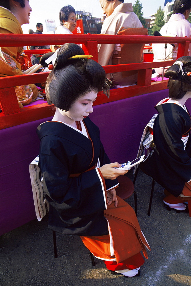 Geisha using mobile phone at Jidai Matsuri Festival held annually in November at Sensoji Temple, Asakusa, Tokyo, Japan, Asia