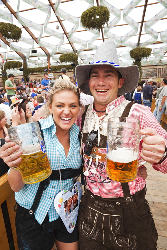 Couple in Bavarian costume drinking beer, Oktoberfest, Munich, Bavaria, Germany, Europe