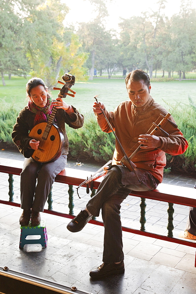 Man and woman playing traditional Chinese stringed instruments, Temple of Heaven Park, Beijing, China, Asia