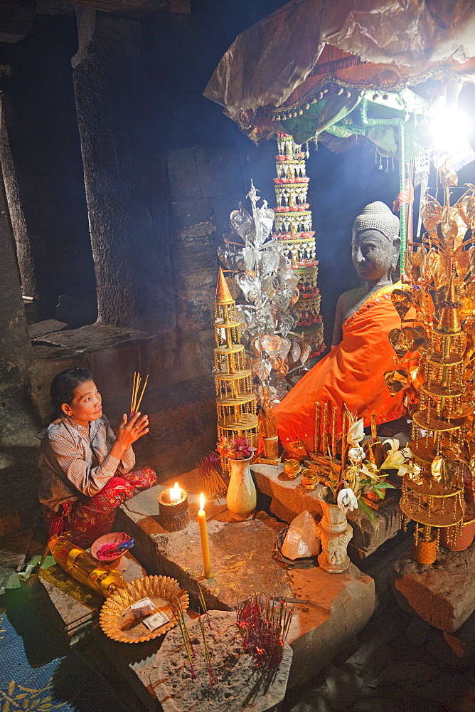 Woman praying to statue of the Buddha, Bayon Temple, Angkor Thom, Angkor, UNESCO World Heritage Site, Siem Reap, Cambodia, Indochina, Southeast Asia, Asia