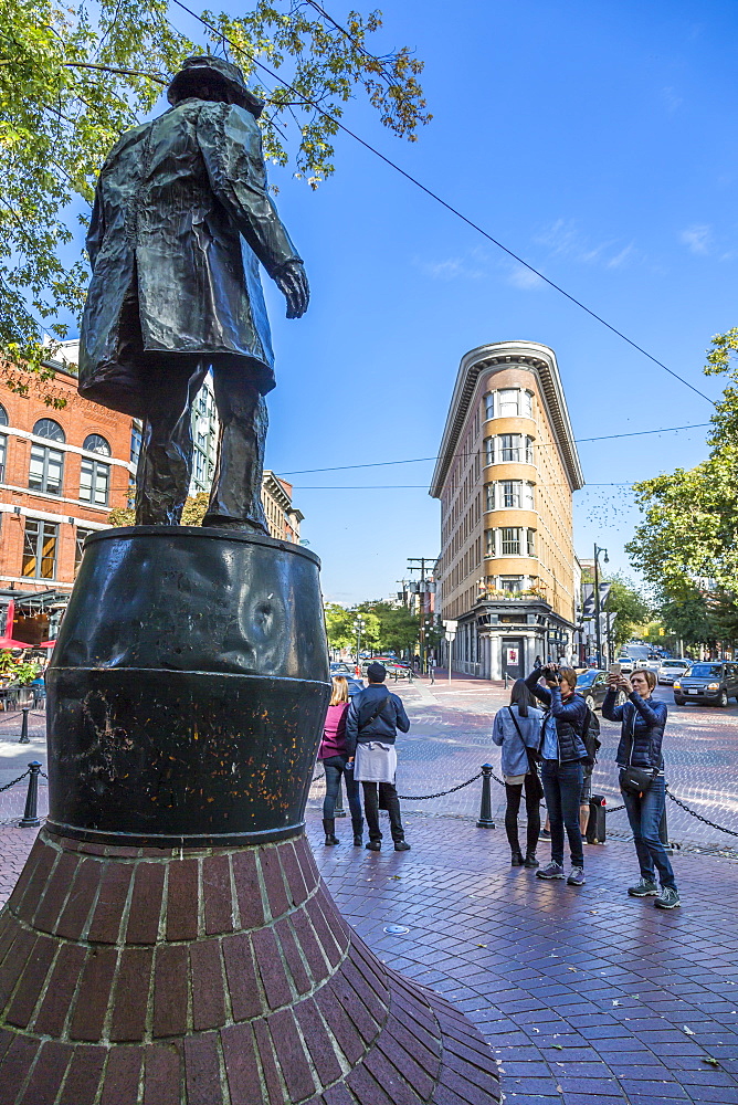 Statue and visitors in Maple Tree Square in Gastown, Vancouver, British Columbia, Canada, North America