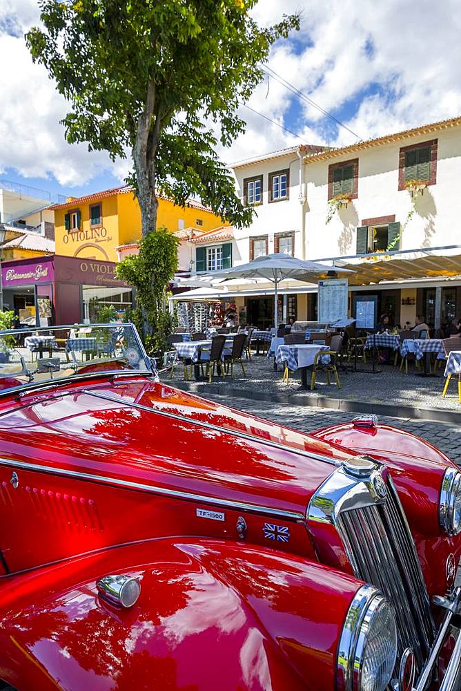 View of red vintage MG car in front of traditional Al Fresco restaurant in old town, Funchal, Madeira, Portugal, Europe