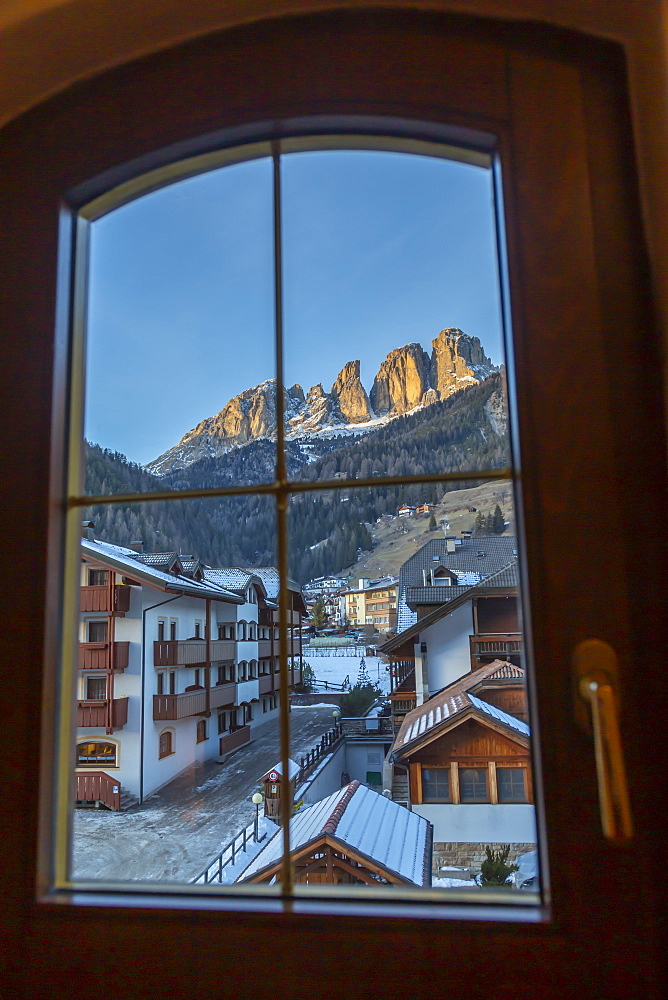 Window view of snow covered Campitello di Fassa and Grohmannspitze Punta Grohmann, Val di Fassa, Trentino, Italy, Europe