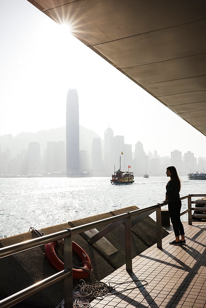 Young woman standing on Tsim Sha Tsui Waterfront, Kowloon, Hong Kong, China, Asia