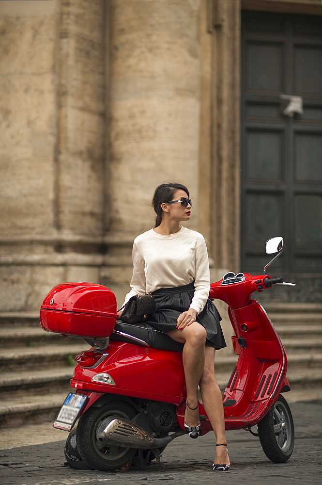 Young woman waiting by Vespa moped, Piazza del Popolo, Rome, Lazio, Italy, Europe