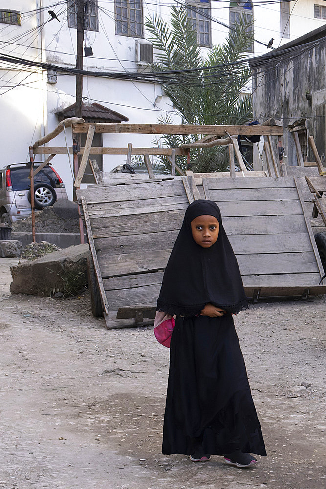 Traditional Muslim girl on her way to school, wearing an abaya, Stone Town, capital of Zanzibar, Tanzania