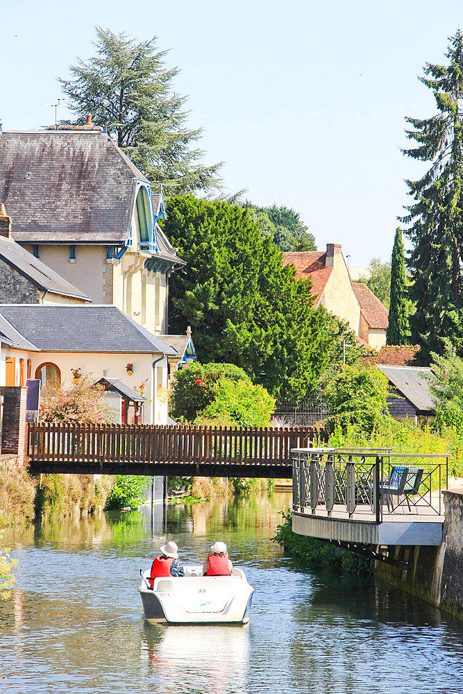 Electric boat on the Huisne river under the name La Venise de l'Ouest. Medieval town of La Ferte Bernard (the beginning of Perche), Sarthe, Pays de la Loire, France