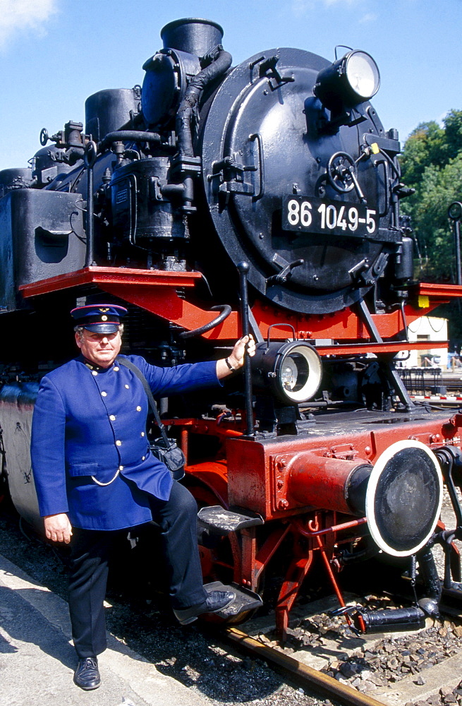 historical steam locomotive typ 86 1049-5 on rails in rail station and railway official wearing historical uniform portrait Annaberg-Buchholz Sachsen Deutschland