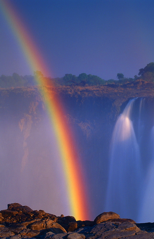 rainbow over waterfall natural phenomenon daytime outdoors vertical format Victoria Falls Zimbabwe Africa