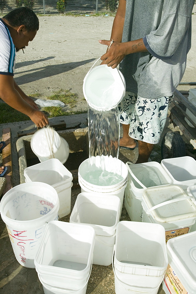 Gathering drinking water harvested from house roofs on Funafuti Atoll, Tuvalu, Pacific