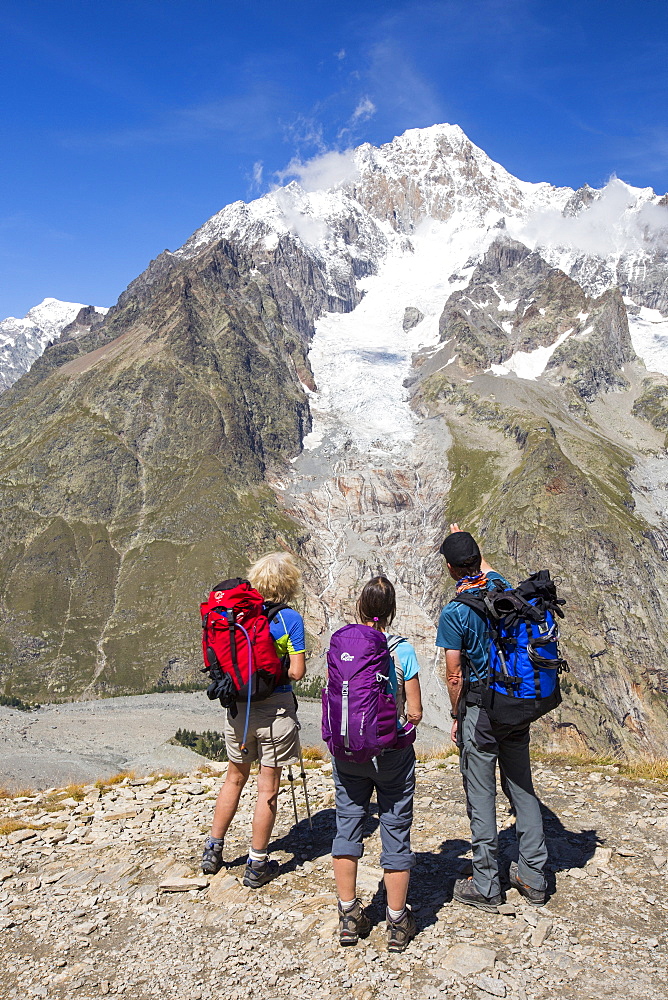 Walkers on the Tour de Mont Blanc ascending out of the Vallon de la Lex Blanche in Italy, below Mont Blanc.