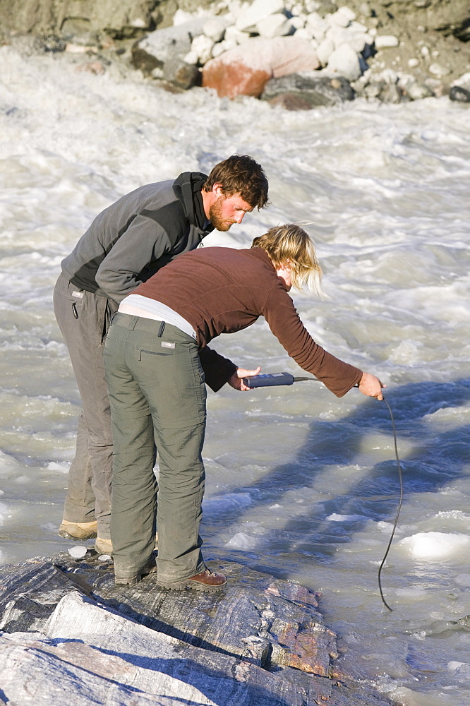 Water temperatures being taken from the meltwater river at the snout of the Russell Glacier near Kangerlussuaq in Greenland, Polar Regions