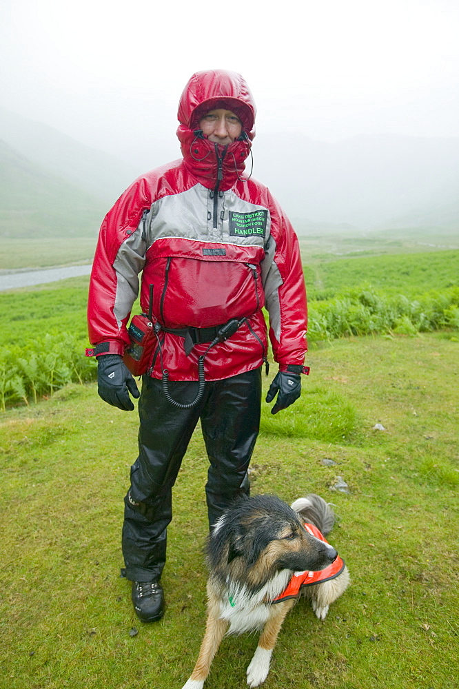 A  search dog handler as a Member of Langdale Ambleside Mountain Rescue Team on a rescue on a very wet day, Lake District, Cumbria, England, United Kingdom, Europe