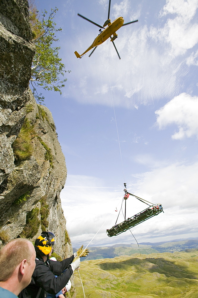 An injured climber with a dislocated shoulder is winched off Jacks Rake, Pavey Ark by the Langdale Ambleside Mountain Rescue Team, Lake District, Cumbria, England, United Kingdom, Europe