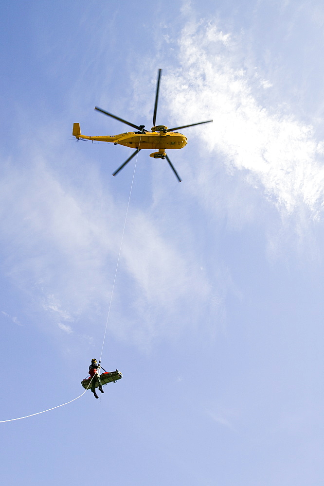 An injured climber with a dislocated shoulder is winched off Pavey Ark by the Langdale Ambleside Mountain Rescue Team and RAF Sea King helicopter, Lake District, Cumbria, England, United Kingdom, Europe