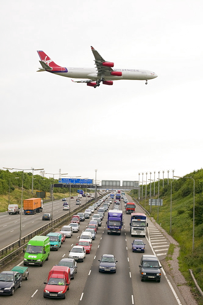 Traffic congestion on the M1 motorway and a plane coming in to land at East Midlands Airport, near Loughborough, Leicestershire, England, United Kingdom, Europe