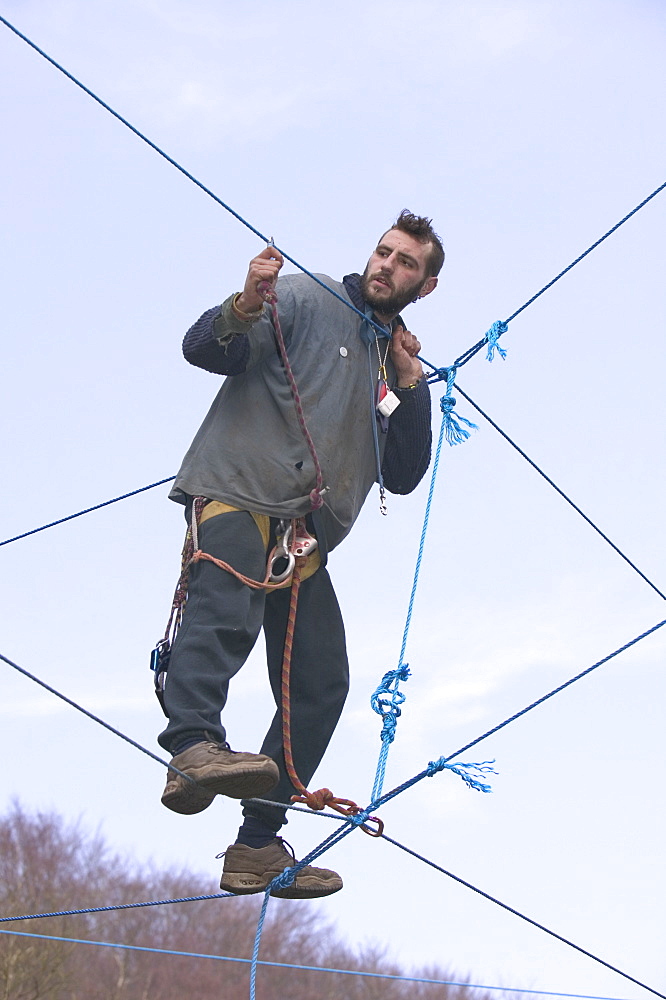 Environmental protestor at the Nine Ladies stone circle camp takes to ropes to avoid bailiffs, Derbyshire, England, United Kingdom, Europe