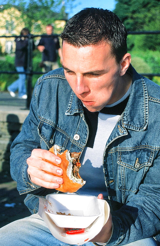 A man eating a burger in public