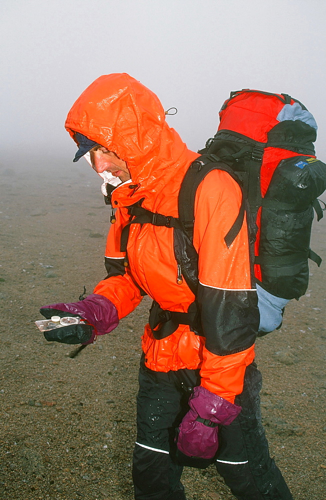 A mountaineer navigating in the Cairngorm mountains in the mist and rain in Scotland, United Kingdom, Europe