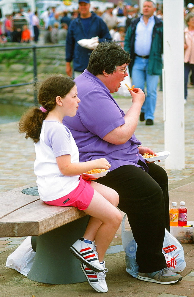 A fat women and daughter easting chips, Whitehaven, Cumbria, England, United Kingdom, Europe