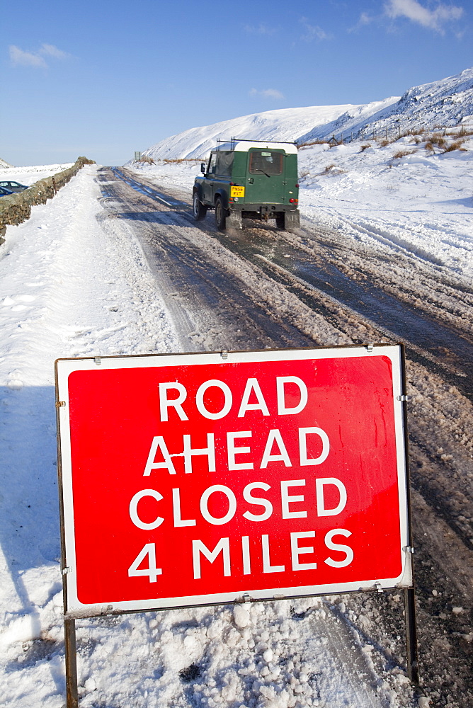 A road closed sign on top of Kirkstone Pass in winter, Lake District, Cumbria, England, United Kingdom, Europe