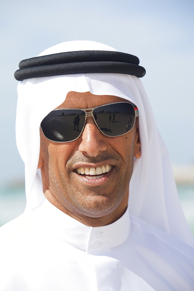 An Arab man wearing traditiional dress on a beach in Dubai, United Arab Emirates, Middle East