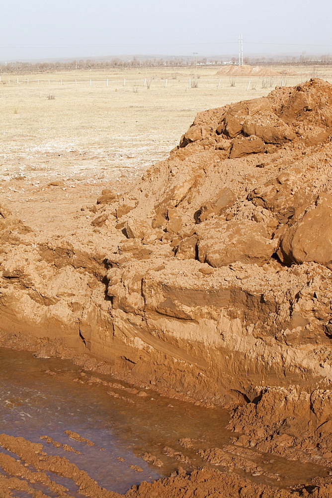 Hole dug by digger in the former lake bed to try and find water, Hong Hai Zai, near Dongsheng, Inner Mongolia, China, Asia