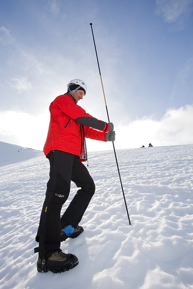 A member of the Scottish Avalanche Information Service demonstrates how to use an avalanche probe on Cairngorm in the Cairngorm National Park in Scotland, United Kingdom, Europe