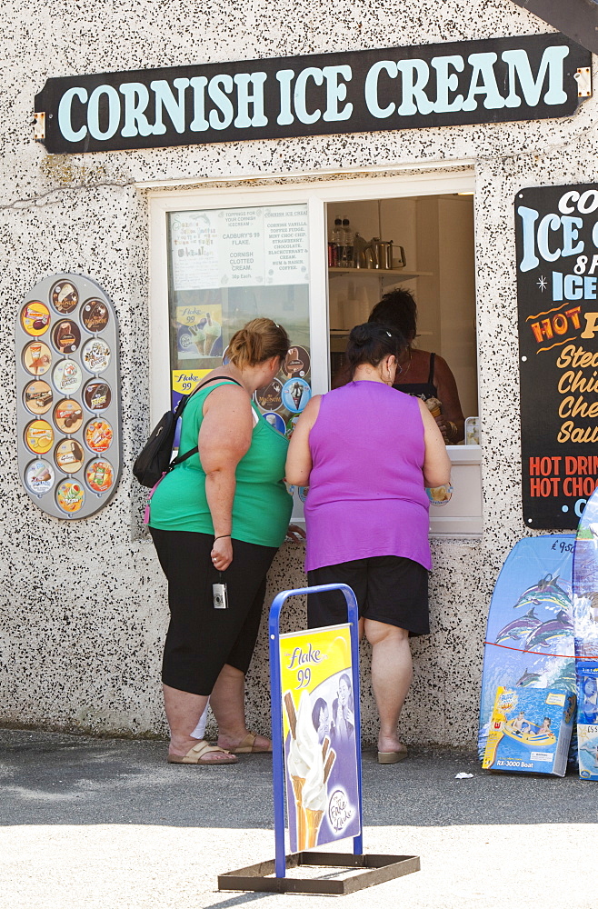 Two obese woman buying ice creams in Sennen Cove, Cornwall, England, United Kingdom, Europe