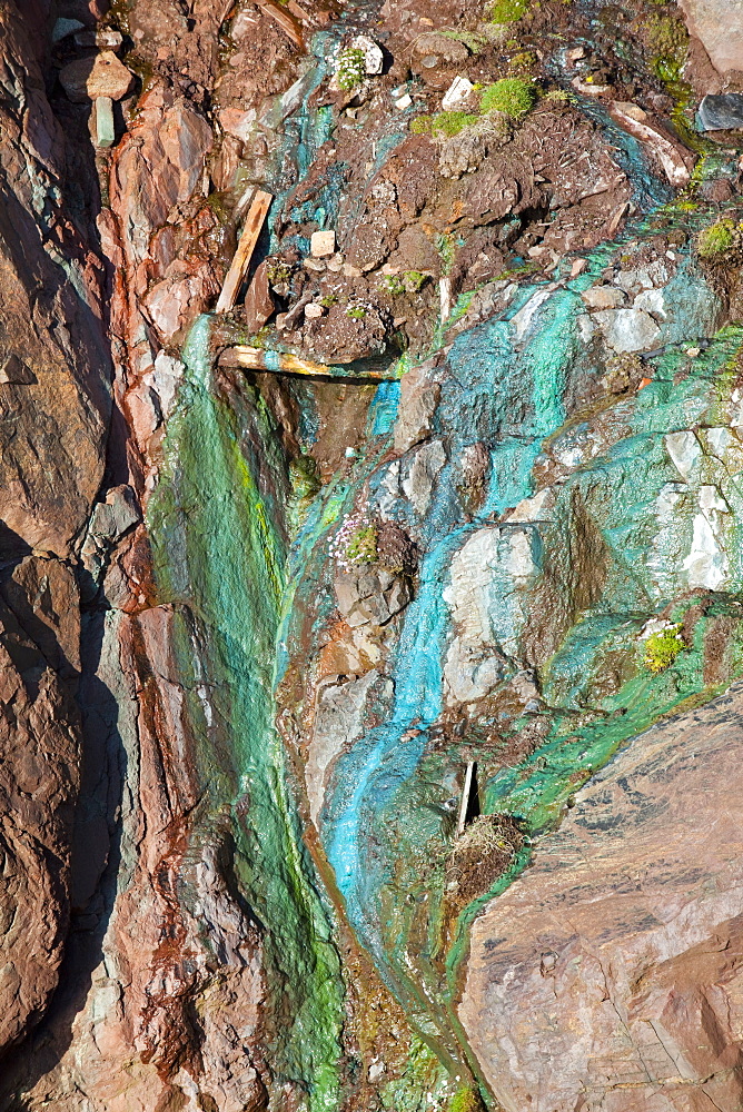 Sea cliffs stained green from copper deposits leaching from the old Geevor Tin Mine near St. Just in Cornwall, England, United Kingdom, Europe