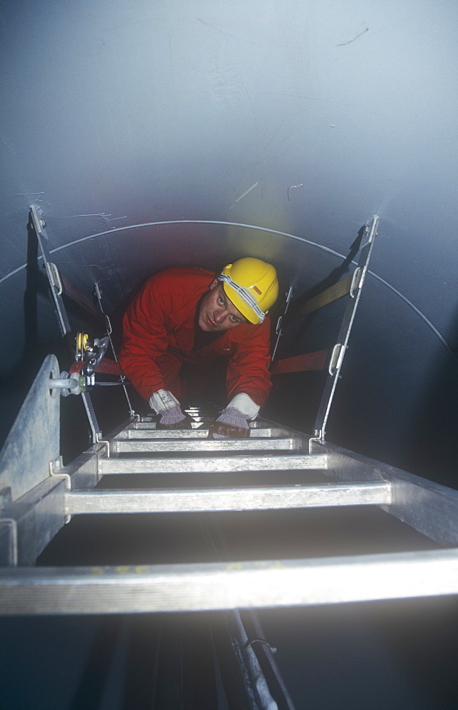 An engineer climbs up the inside of a wind turbine above Ulverston, Cumbria, England, United Kingdom, Europe