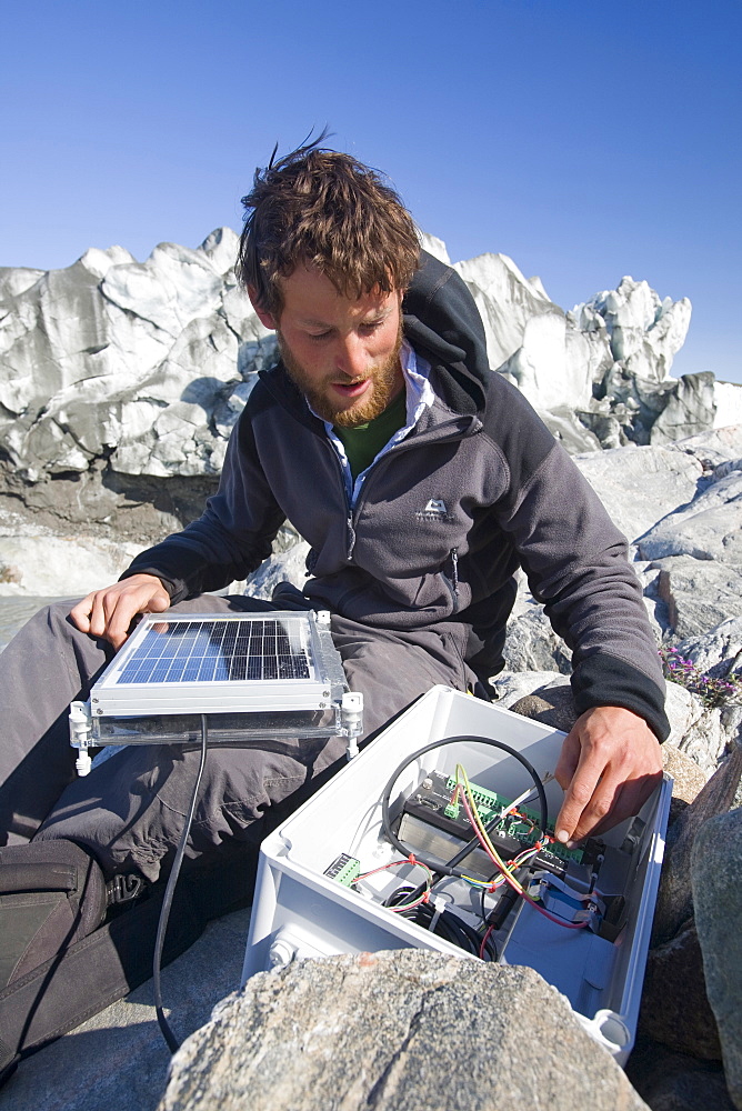 PHD scientist Ian Bartholomew taking measurements as part of a study to measure the speed of the Russell Glacier near Kangerlussuaq, Greenland, Polar Regions