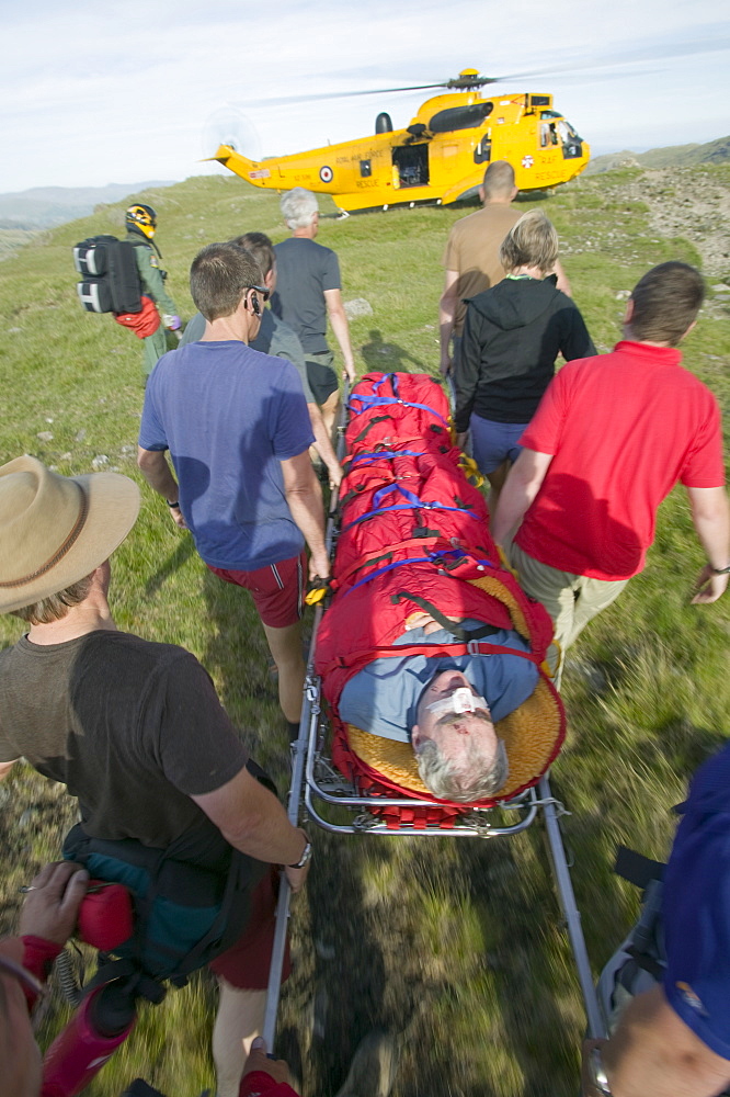 Memers of Langdale Ambleside mountain rescue team evacuate an injured walker on Bow Fell in the Lake District, Cumbria, England, United Kingdom, Europe