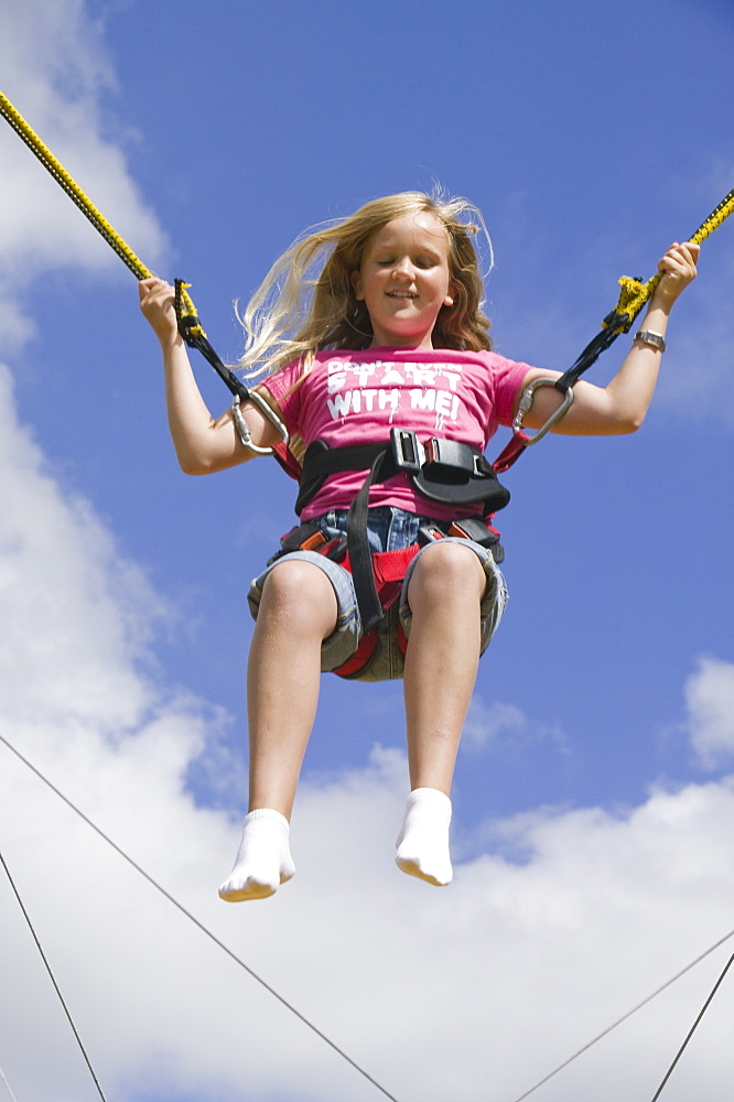 A child on a bungee machine at Ambleside Sports, Lake District, Cumbria, England, United Kingdom, Europe