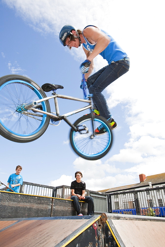 Teenage boys perform aerial stunts on BMX bikes at a BMX park in Rhyl, North Wales, United Kingdom, Europe