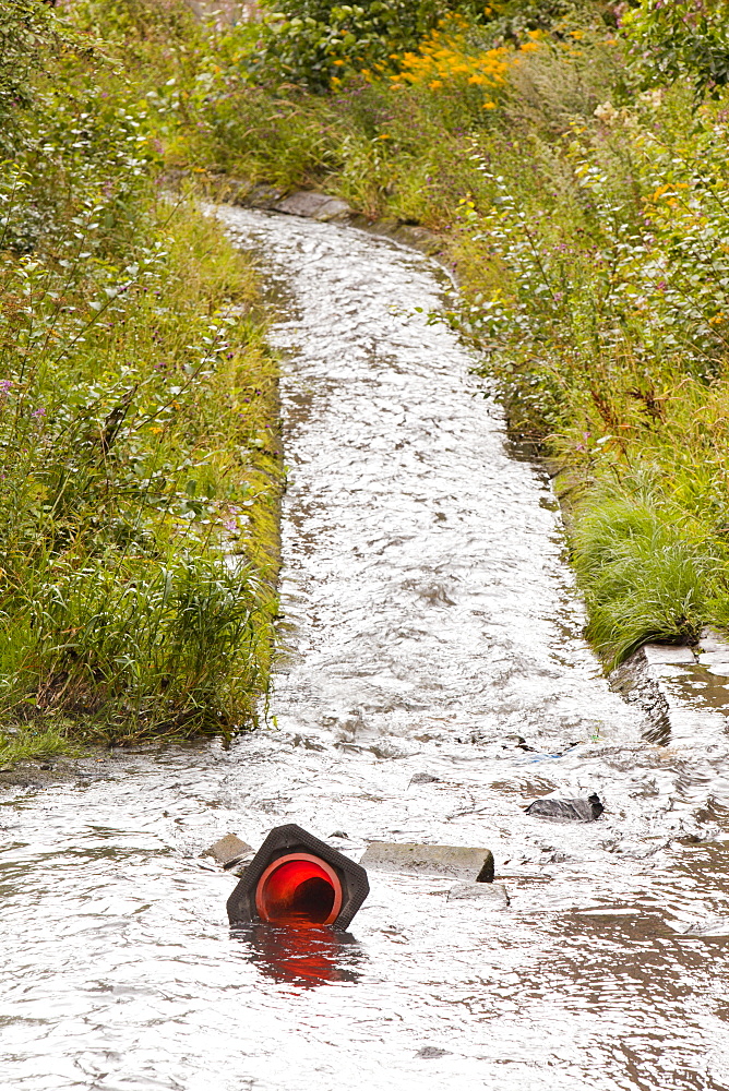 Traffic cone in an urban river running through the centre of Burnley in Lancashire, England, United Kingdom, Europe