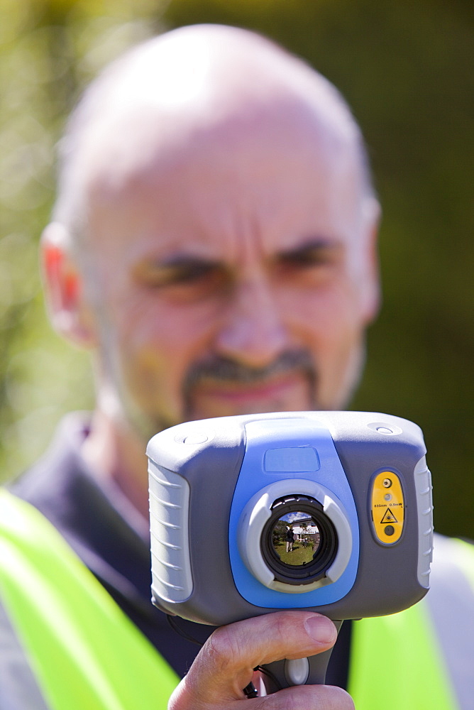 A technician uses a thermal imaging camera to check the thermal efficiency of a house, and where heat is lost from the house, United Kingdom, Europe