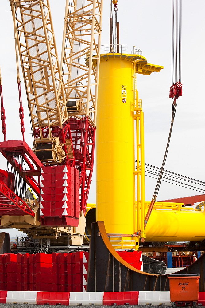 The yellow transition pieces that will hold the tower and turbine, that fit onto the monopile to hold the structure to the sea bed, Walney Offshore Wind Farm, Barrow in Furness, Cumbria, England, United Kingdom, Europe