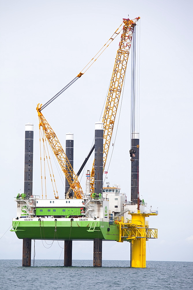 The jack up barge that hammers the monopiles into the sea bed fits a transition piece onto the top of the monopile, Walney Offshore Wind Farm, Cumbria, England, United Kingdom, Europe