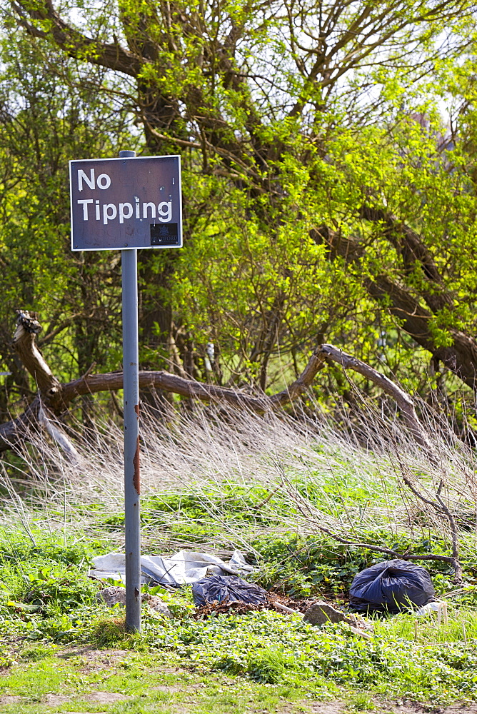 Rubbish illegally dumped next to a no tipping sign in Saltaire, Yorkshire, England, United Kingdom, Europe