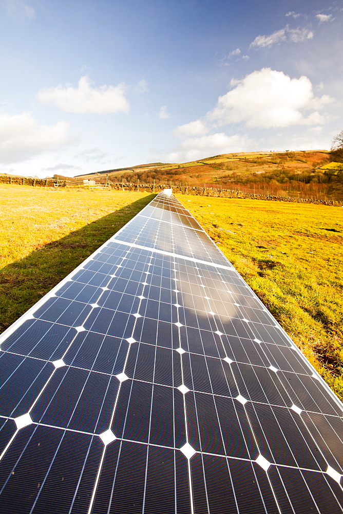 Solar panels in a field behind a farm house powered by them on the edge of Ilkley Moor, West Yorkshire, Yorkshire, England, United Kingdom, Europe