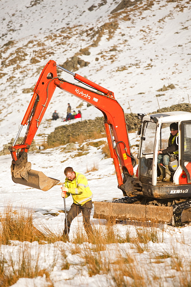 Workmen start the initial groundworks for three wind turbines to be constructed behind the Kirkstone Pass Inn on Kirkstone Pass in the Lake District, Cumbria, England, United Kingdom, Europe