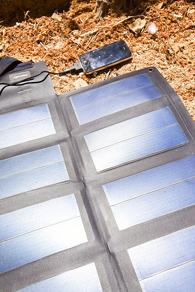 A portable solar mat used to recharge a mobile phone in the Anti Atlas mountains of Morocco, North Africa, Africa