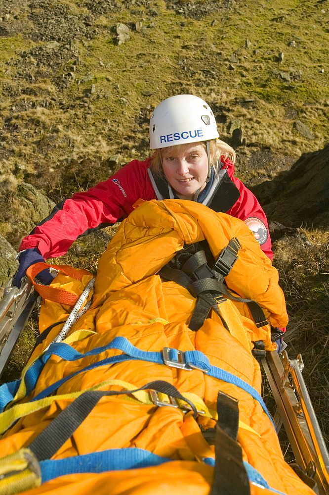 Members of Langdale Ambleside Mountain Rescue Team lower a stretcher down a crag as part of a training exercise, Lake District, Cumbria, England, United Kingdom, Europe