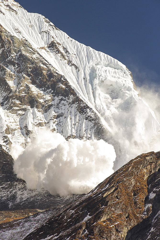 An avalanche on Machapuchare (Fishtail Peak) in the Annapurna Himalaya, Nepal, Asia