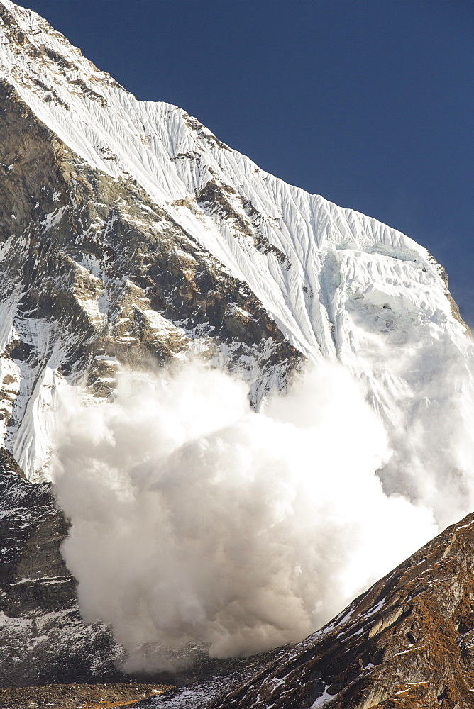 An avalanche on Machapuchare (Fishtail Peak) in the Annapurna Himalaya, Nepal, Asia