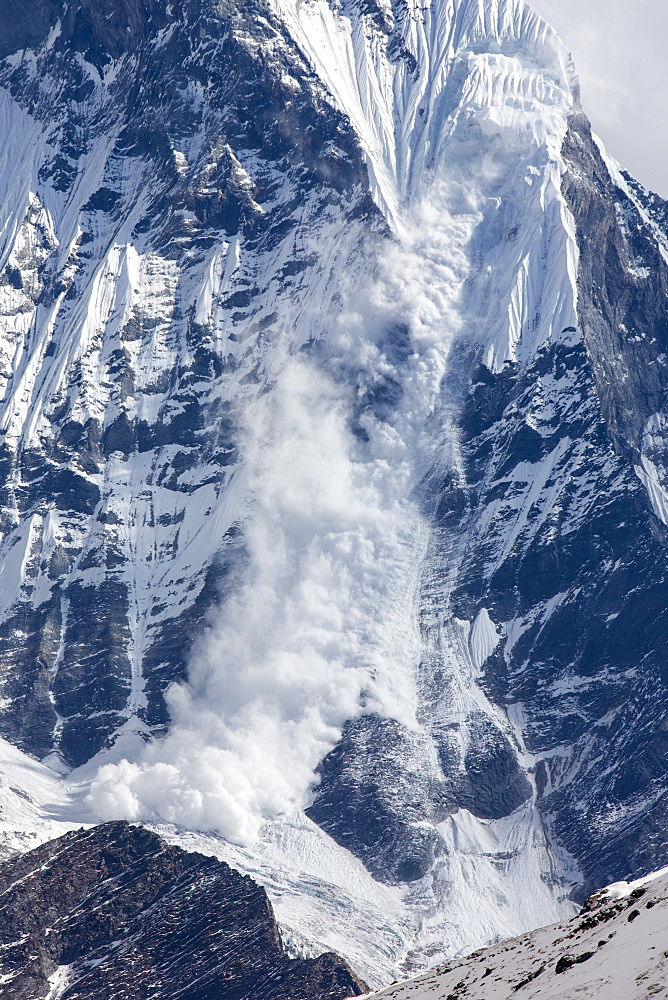 An avalanche on Machapuchare (Fishtail Peak) in the Annapurna Himalaya, Nepal, Asia