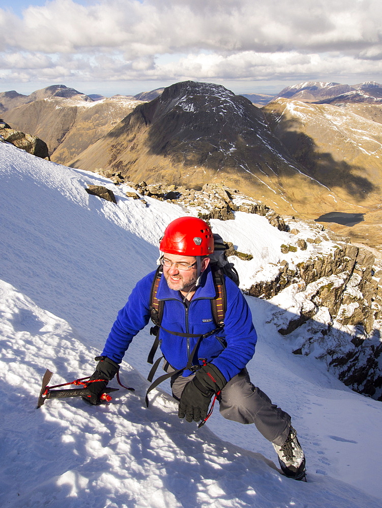 A climber topping out in Custs Gully on Great End, a grade one winter route, Lake District, Cumbria, England, United Kingdom, Europe