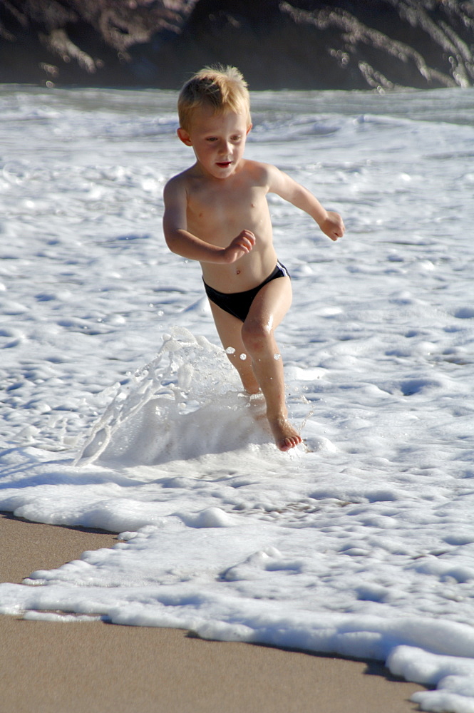 Boy running at water's edge, West Dale