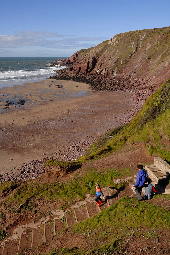 Mother and children going down steps to West Dale beach, Dale, Pembrokeshire, Wales, UK, Europe